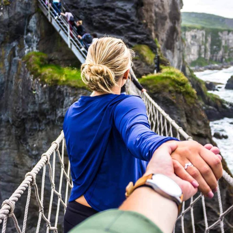 A couple crossing a rope bridge