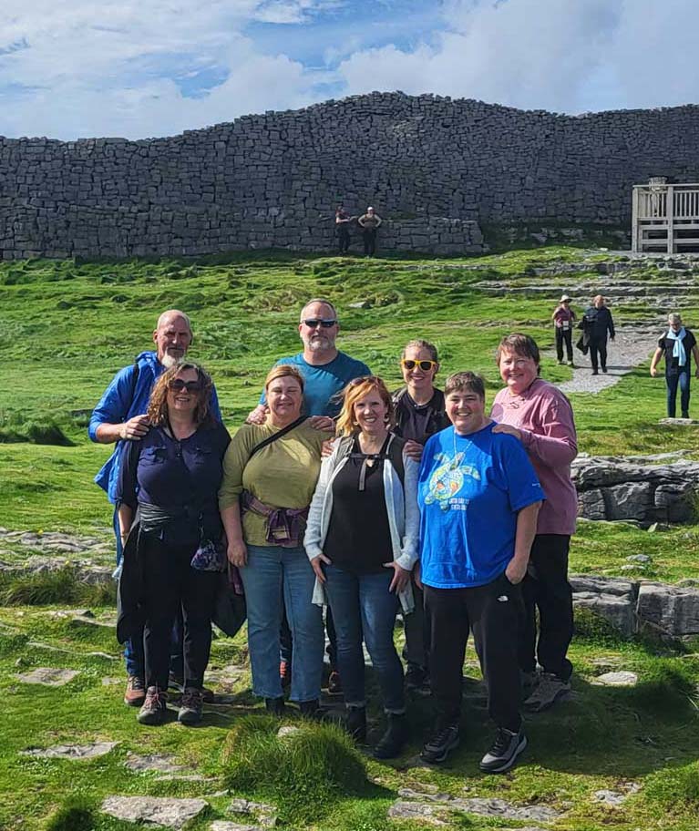 A smiling group of people in front of a monument